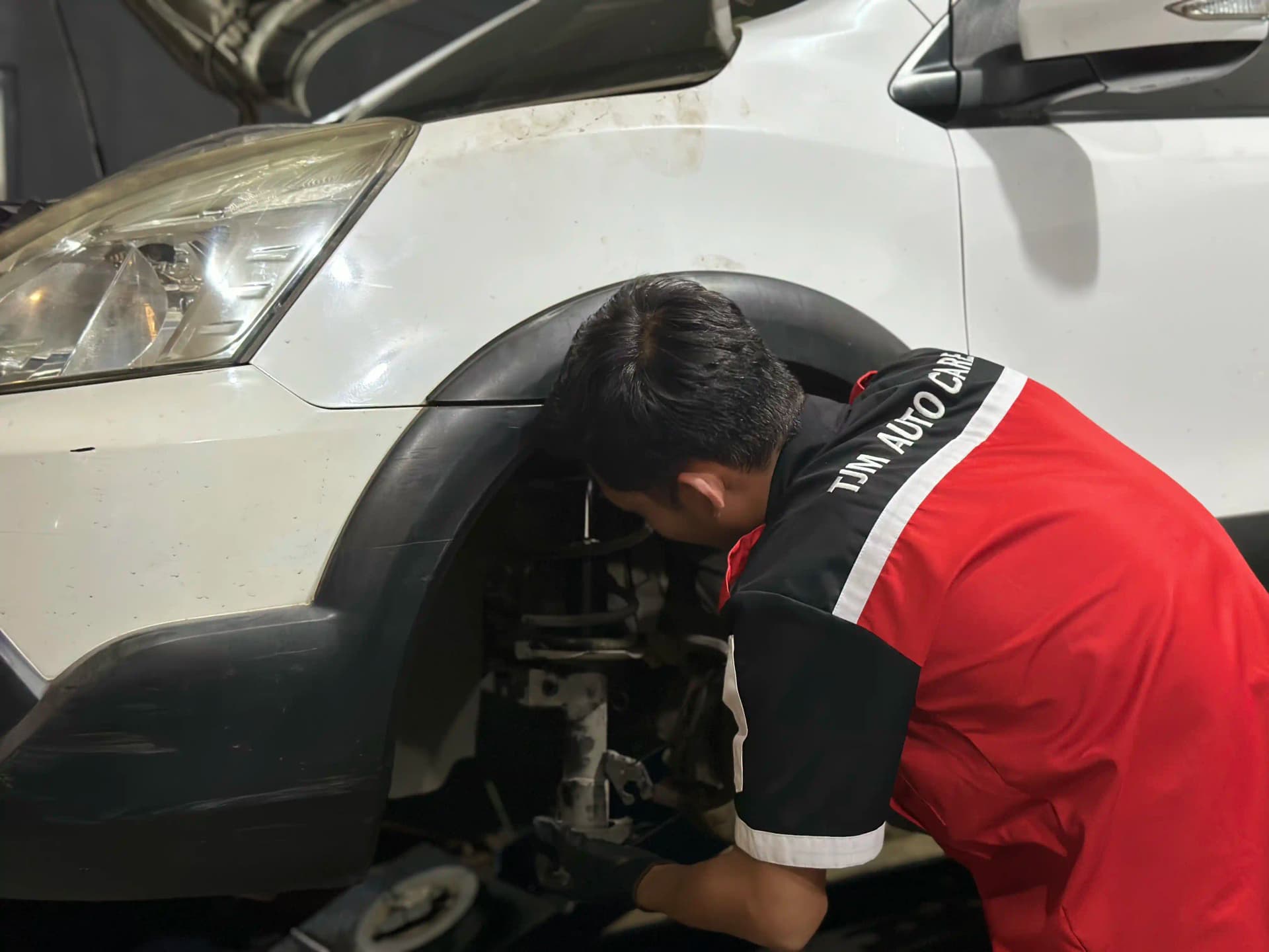 Mekanik memperbaiki suspensi roda belakang